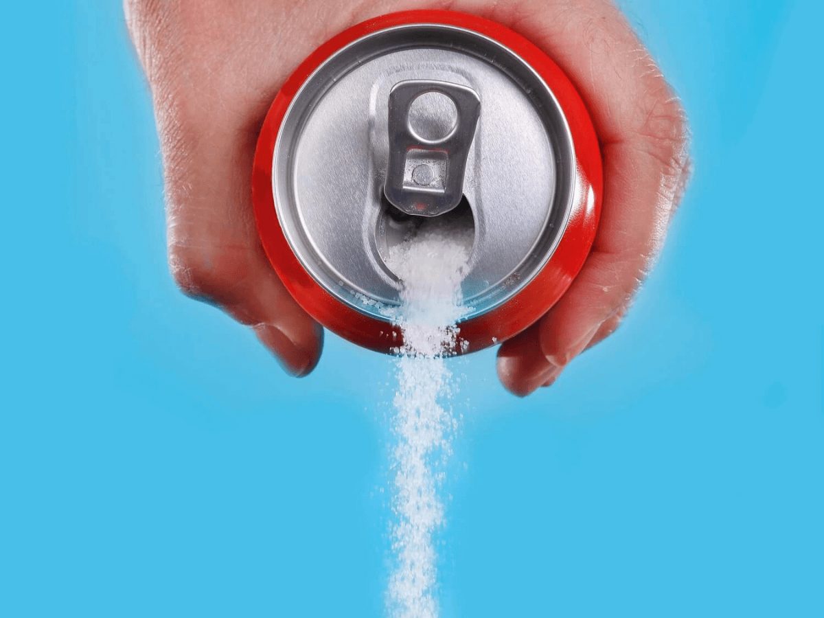 podatek cukrowy: wysypywanie cukru z puszki po napoju